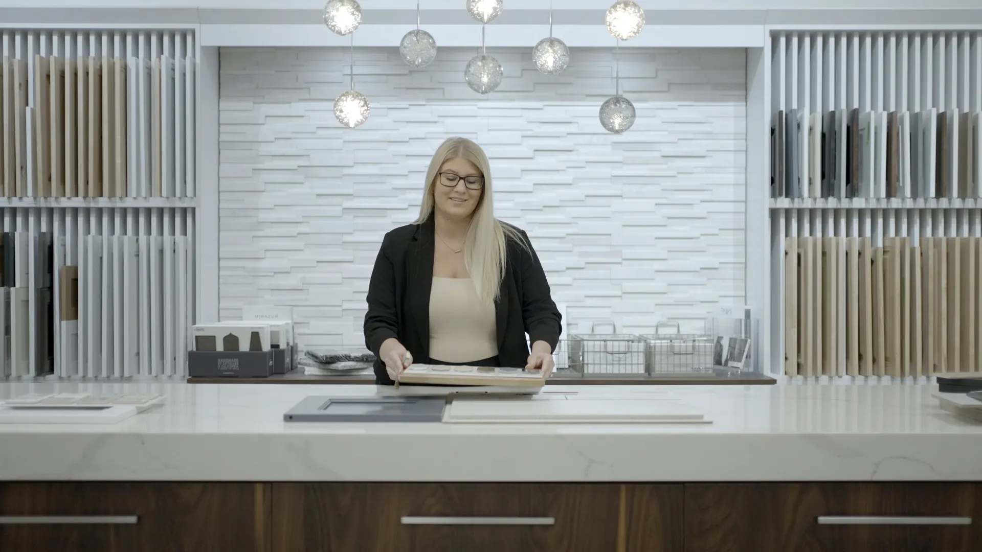 An employee lays out sample tiles and cabinet doors in a showroom.